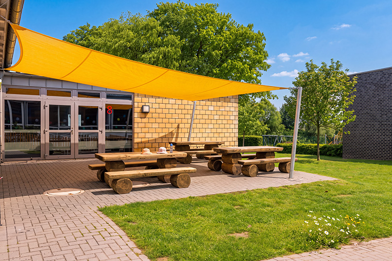 Ortsfestes und viereckiges Sonnensegel an der Sonnenterrasse des Außenbereichs an der Grundschule Bruchmühlen